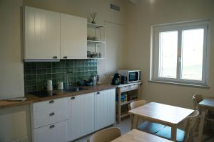 a kitchen with white cabinets and a table and a window at Masseria Marchesani in Montenero di Bisaccia