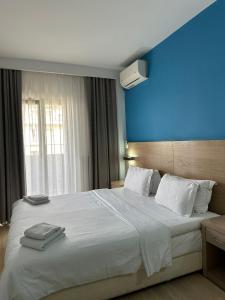 a bedroom with a large white bed with a blue wall at Rotonda Hotel in Thessaloniki +94 photos