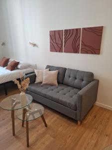 a living room with a couch and a table at Studio de charme - Centre Vienne - Proche gare in Vienne