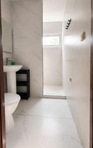 a white bathroom with a shower and a toilet at Rowyhills in Rowy
