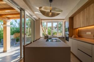 a kitchen with a large island and a large window at Charme Villa La Vela - Goelba in Lacona