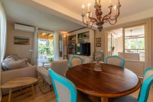 a dining room and living room with a table and chairs at Charme Villa La Vela - Goelba in Lacona