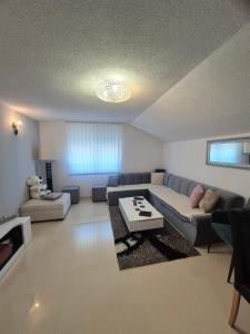 a living room with a couch and a table at Apartman IN in Bihać