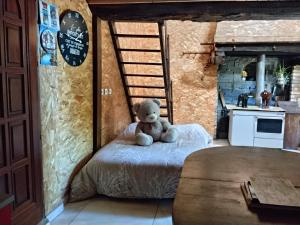 a teddy bear sitting on a bed in a kitchen at Le Mont Rochard in Sainte-Gemmes-le-Robert