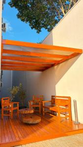 a wooden deck with benches and awning on a building at Hotel Seville Comfort in Telêmaco Borba