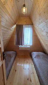 a bedroom with two beds in a wooden cabin at Riverside Ghari Cottages in Oni +26 photos