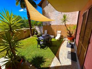 a patio with a table and chairs in a yard at Foresteria Kiki in Gravedona