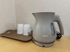 a white coffee pot sitting on top of a table at 水之道 in Osaka