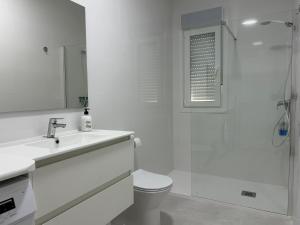 a white bathroom with a toilet and a shower at Catalina in Mondariz +17 photos