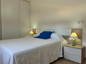a bedroom with a white bed with a blue towel on it at Catalina in Mondariz