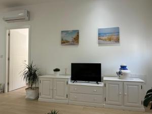 a living room with a television on a white cabinet at Catalina in Mondariz