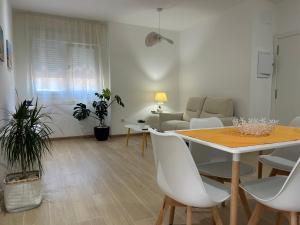 a dining room and living room with a table and chairs at Catalina in Mondariz