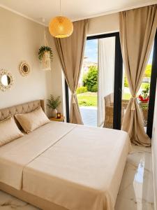 a bedroom with a large bed and a large window at Amore Fanari in Fanari