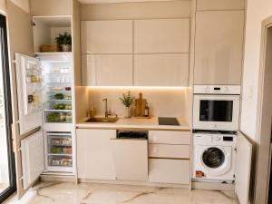 a kitchen with white cabinets and a washer and dryer at Amore Fanari in Fanari