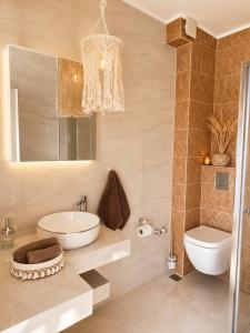 a bathroom with a sink and a toilet and a chandelier at Amore Fanari in Fanari +5 photos