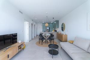a living room and kitchen with a couch and a table at LA Paz - Sunny Pool Retreat - Jacuzzi - Near Beach in Los Alcázares