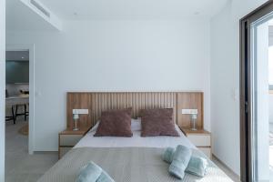 a bedroom with a large bed with two pillows at LA Paz - Sunny Pool Retreat - Jacuzzi - Near Beach in Los Alcázares +52 photos