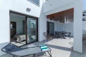 a patio with a bed and a table and chairs at LA Paz - Sunny Pool Retreat - Jacuzzi - Near Beach in Los Alcázares