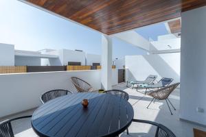 a blue table and chairs on a balcony at LA Paz - Sunny Pool Retreat - Jacuzzi - Near Beach in Los Alcázares