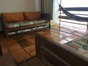 a couch sitting on a tiled floor in a room at Dúplex Frente Mar na ilha de Itaparica in Vera Cruz de Itaparica