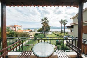 a balcony with a table and a view of the ocean at Ariadnes Holiday Accommodation in Apidias Lakos