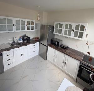 a large kitchen with white cabinets and appliances at Cozy Home 2 Bedroom apartment in Kyustendil