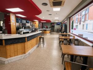 a restaurant with a bar and tables and chairs at Hostal Goyma III in San Fernando de Henares