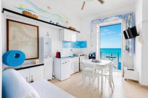 a kitchen with a table and a view of the ocean at Casa Nettuno in Ostuni