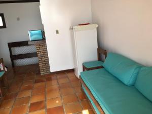 a living room with a couch and a refrigerator at Dúplex Frente Mar na ilha de Itaparica in Vera Cruz de Itaparica