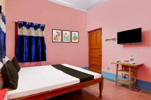 a bedroom with a bed and a tv on a wall at Super Hotel O A.R. Lodge in Durgāpur