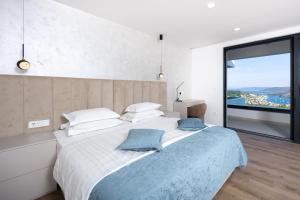 a bedroom with a large bed with a large window at View Villas Collection in Vinišće +62 photos
