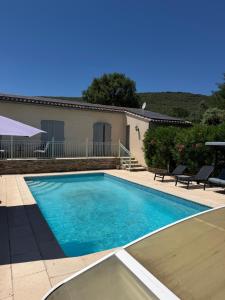 a swimming pool in front of a house at Studio privé in Cazilhac