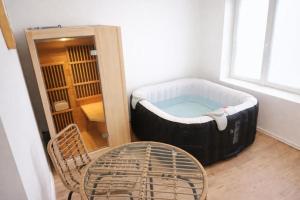 a room with a bath tub with a table and a chair at Glamping - accès JACUZZI et SAUNA in Boulogne-sur-Mer