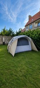 a tent sitting on the grass in a yard at Glamping - accès JACUZZI et SAUNA in Boulogne-sur-Mer