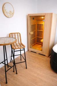 a room with a table and a chair and a door at Glamping - accès JACUZZI et SAUNA in Boulogne-sur-Mer