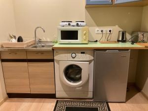 a kitchen with a washing machine and a microwave at Jaani 2 Apartment in Pärnu