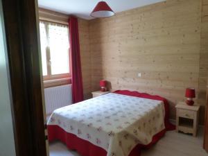 a bedroom with a bed with a table and a window at Le Fayet d'en haut in Abondance