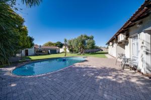 a swimming pool in a yard next to a house at 16 Vaalrivier in Secunda