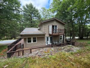 a small house with a porch and a deck at Poconos Hideaway in Greentown