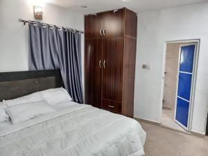 a bedroom with a large bed and a wooden cabinet at Naira and Kobo Hotel in Umuahia