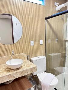a bathroom with a sink and a toilet and a mirror at Pousada Mares Maragogi in Maragogi +7 photos