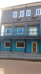 a blue building with windows and a balcony at Naira and Kobo Hotel in Umuahia
