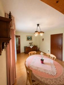 a dining room with a table with a vase of flowers on it at Ferienwohnung Grebe in Breidenbach