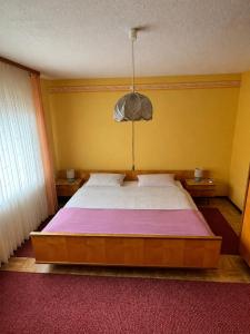 a bedroom with a large bed in a yellow wall at Ferienwohnung Grebe in Breidenbach