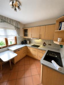 a kitchen with wooden cabinets and a tile floor at Ferienwohnung Grebe in Breidenbach