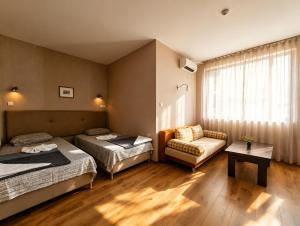 a hotel room with two beds and a chair at Europroperties Yalta Apartments in Golden Sands +72 photos