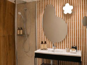 a bathroom with a sink and a large mirror at Mercure Nice Promenade Des Anglais in Nice