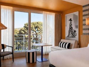 a hotel room with a bed and a large window at Mercure Nice Promenade Des Anglais in Nice