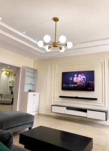 a living room with a flat screen tv on a wall at Kays Royal Suite in Isasi