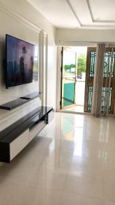 a living room with a flat screen tv on a wall at Kays Royal Suite in Isasi +11 photos